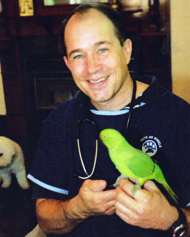 Dr Ken Robinson with a green bird